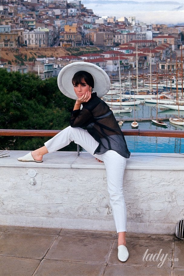 Френсіс Патікі Штайн у яхтовій гавані Турколімано, Греція, у білих бавовняних штанах, чорній сорочці та білому солом’яному капелюсі від Adolfo / © Getty Images